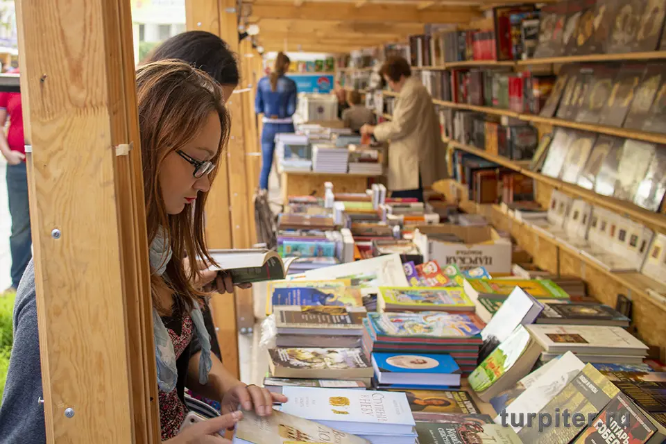 девушка читает книгу на ярмарке книг
