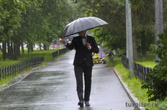 мужчина в бабочке идет под дождем в Петербурге