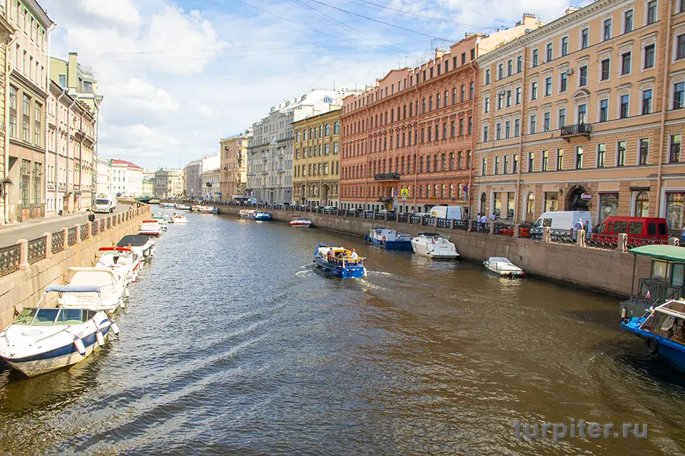 кораблик плывет по реке Мойка в Санкт-Петербурге