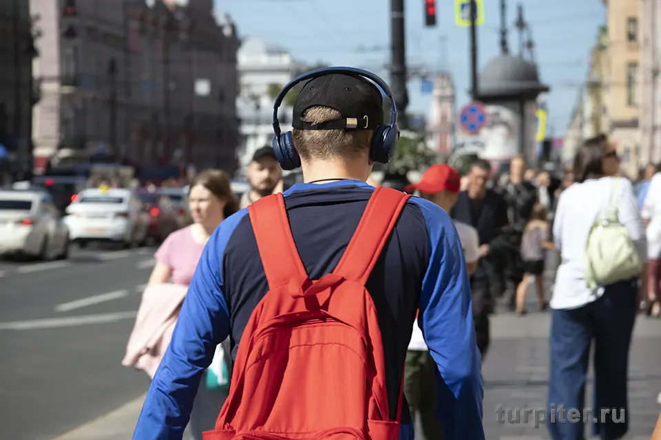 парень идет по Невскому проспекту в наушниках